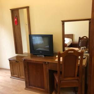 a television sitting on top of a desk with a mirror at Hotel Transilvania in Cluj-Napoca