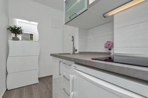 a white kitchen with a sink and a refrigerator at Apartment Kate in Podgora +51 photos