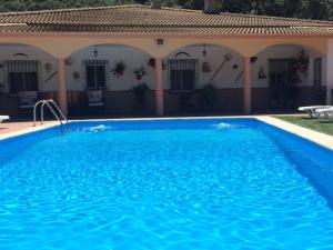 a swimming pool in front of a house at Villa La Quinta in Priego de Córdoba
