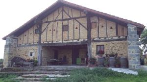 una antigua casa de piedra con un patio frente a ella en Alojamiento Rural Goierri, en Barrika