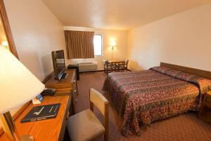 a hotel room with a bed and a table and a desk at Superior Inn in Superior