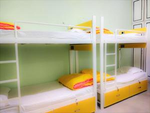 a room with three bunk beds with yellow and white at The Desire Hostel in New Delhi