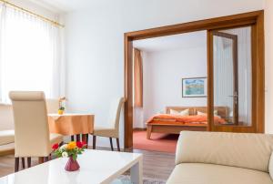 ein Wohnzimmer mit Sofa und ein Schlafzimmer in der Unterkunft Hotel Weltrich in Saalfeld