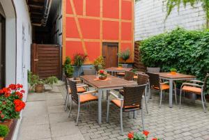 un patio esterno con tavoli, sedie e fiori di Hotel Weltrich a Saalfeld