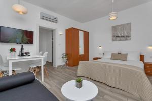 a bedroom with a bed and a table and a desk at Apartment Kate in Podgora