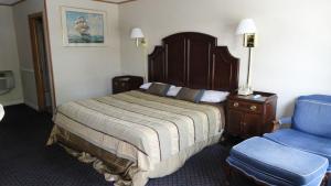 a hotel room with a bed and a blue chair at Harbor Base Inn in Newport