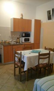 a kitchen with a table with chairs and a microwave at Apartmani Božić-Omišalj in Omišalj