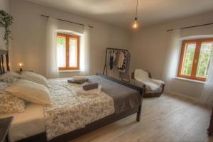 a bedroom with a large bed and a chair at Apartman Toni in Lukoran