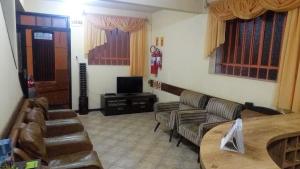 a waiting room with couches and a table and a tv at Kontiki Hotel in São Francisco do Sul
