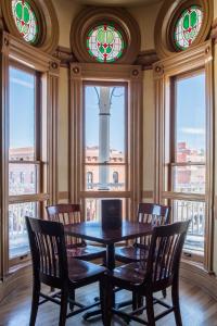 a dining room with a table and chairs and stained glass windows at Weatherford Hotel in Flagstaff