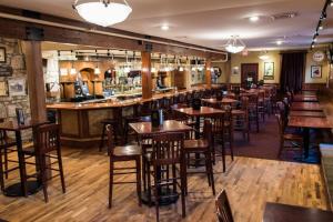 a bar in a restaurant with wooden tables and chairs at Weatherford Hotel in Flagstaff