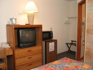 a room with a tv on a dresser and a bed at Sea Spray Motel in Beach Haven