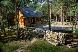 a log cabin in the woods with a stone wall at Łosia Chata in Grzybowce