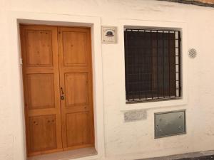 una porta in legno e una finestra su un edificio di casa vacanza Regina a Grottaglie