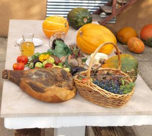 a table with pumpkins and a basket of fruit and vegetables at Rooms Marija - rooms with pool in Trilj
