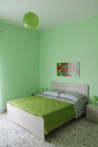 a bedroom with a large bed with a green blanket at Casa Michelina in Belvedere Marittimo