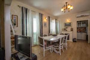 a dining room with a table and chairs and a tv at Apartment Valerija in Jesenice +9 photos