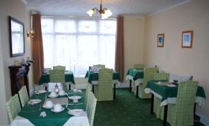a dining room with green tables and chairs at Trevellis Bed and Breakfast in Newquay