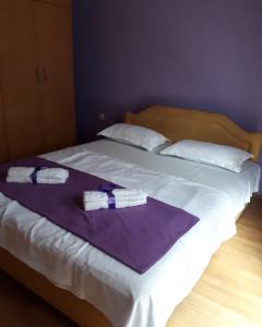a large white bed with two towels on it at Apartments Vitic in Sutomore