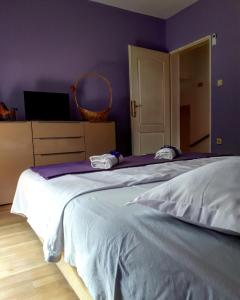 a bedroom with a large bed with purple walls at Apartments Vitic in Sutomore