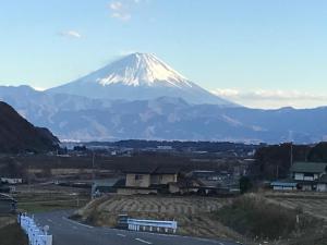 a snow covered mountain in the distance with a road at Alps Lodge & Spa in Hokuto