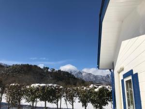 a view of a snowy mountain range from a house at Alps Lodge & Spa in Hokuto