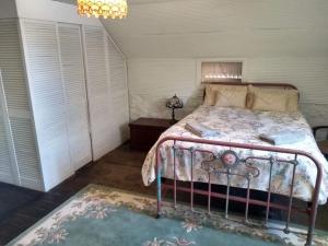 a bedroom with a bed with a metal frame at Tanilba House in Lemon Tree Passage