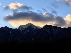 a sunset over a mountain range with a cloud at Alps Lodge & Spa in Hokuto +50 photos