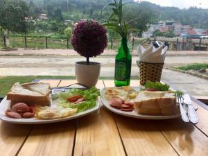 a table with two plates of food and a bottle of beer at Bac Ha Boutique Homestay in Bắc Hà
