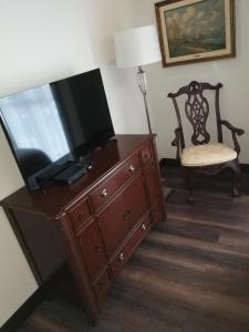 a television on top of a dresser with a chair at Casa Corp Boutique Suites in Condesa in Mexico City