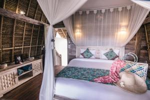 a bedroom with a bed and a window at Dream Beach Huts in Nusa Lembongan