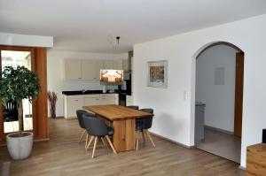 a kitchen and dining room with a wooden table and chairs at Crastuoglia 855-1 in Scuol