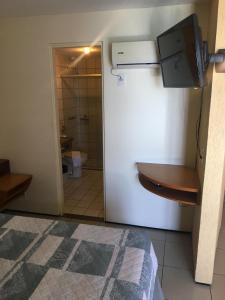 a room with a refrigerator and a bathroom with a toilet at FortalezAmar Hotel Praia Mansa in Fortaleza