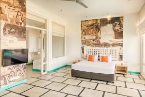 Hotel J Negombo في نيجومبو: غرفة نوم بسرير وجدار فيه كتابات على الجدران