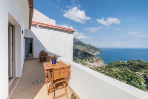 a balcony with a table and chairs overlooking the ocean at L'Angolo dei Sogni in Ravello