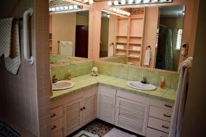 a bathroom with two sinks and two mirrors at Cariari Bed & Breakfast in San José