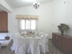 comedor con mesa blanca y sillas blancas en Quinta Valvanera en Salta