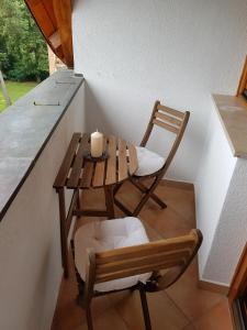 a small table and chair with a candle on a counter at Napsugár Apartman in Balatonlelle