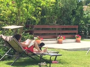two people laying in a lawn chair in a yard at Arli Hotel Hideaway Punta Ala - Adults Only in Punta Ala