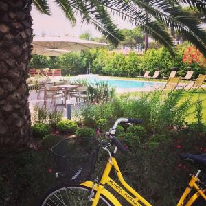 a yellow bike parked next to a swimming pool at Arli Hotel Hideaway Punta Ala - Adults Only in Punta Ala