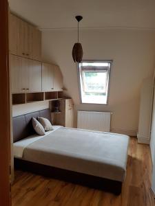 a bedroom with a large bed and a window at Napsugár Apartman in Balatonlelle