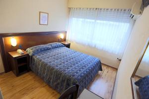 a hotel room with a bed and a window at Hotel Eldorado in Salto