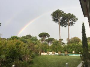 a rainbow over a yard with chairs and a pool at Arli Hotel Hideaway Punta Ala - Adults Only in Punta Ala