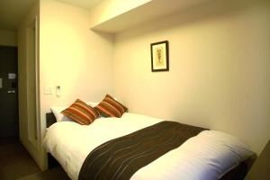Value The Hotel Higashi Matsushima Yamoto في Higashimatsushima: غرفة نوم عليها سرير ووسادتين