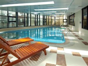 a large swimming pool with a bench in a building at Mercure Beijing Downtown in Beijing