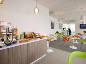 a restaurant with a counter with food on it at ibis Styles Grenoble Centre Gare in Grenoble