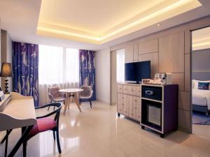 a hotel room with a kitchen and a living room at Mercure Jakarta Sabang in Jakarta