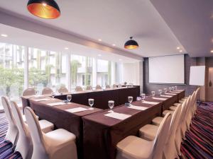 a conference room with a long table and chairs at Mercure Jakarta Sabang in Jakarta