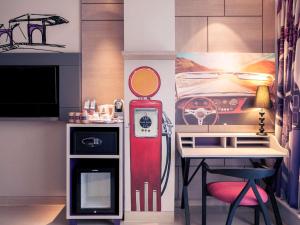 a kitchen with a red refrigerator next to a table at Mercure Jakarta Sabang in Jakarta