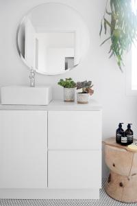 a white bathroom with a sink and a mirror at Stunning Flourish ON Bull in Newcastle